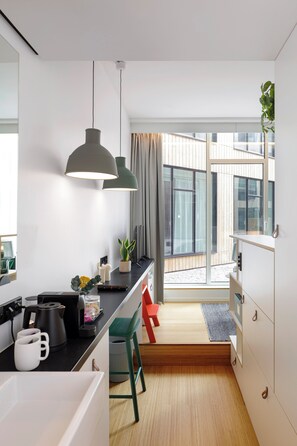 Una cocina moderna con luces colgantes, una cafetera y vistas al exterior.