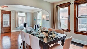 A dining area with a dark wooden table set for six, surrounded by six chairs. - Designer House 5BR! Steps to Downtown/Fountain Sq! (Indianapolis)