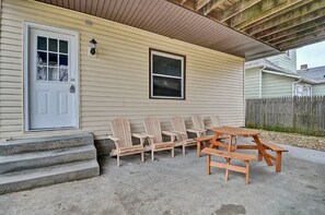 A house with a front porch, a wooden bench, and a picnic table.