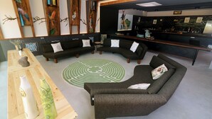 A modern interior with a curved sofa set, a wooden coffee table with decorative vases, and a green patterned rug.