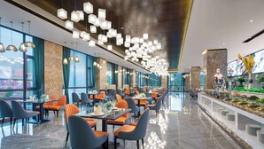 Un restaurante espacioso con decoración moderna, grandes ventanales y diversas opciones de asientos.
