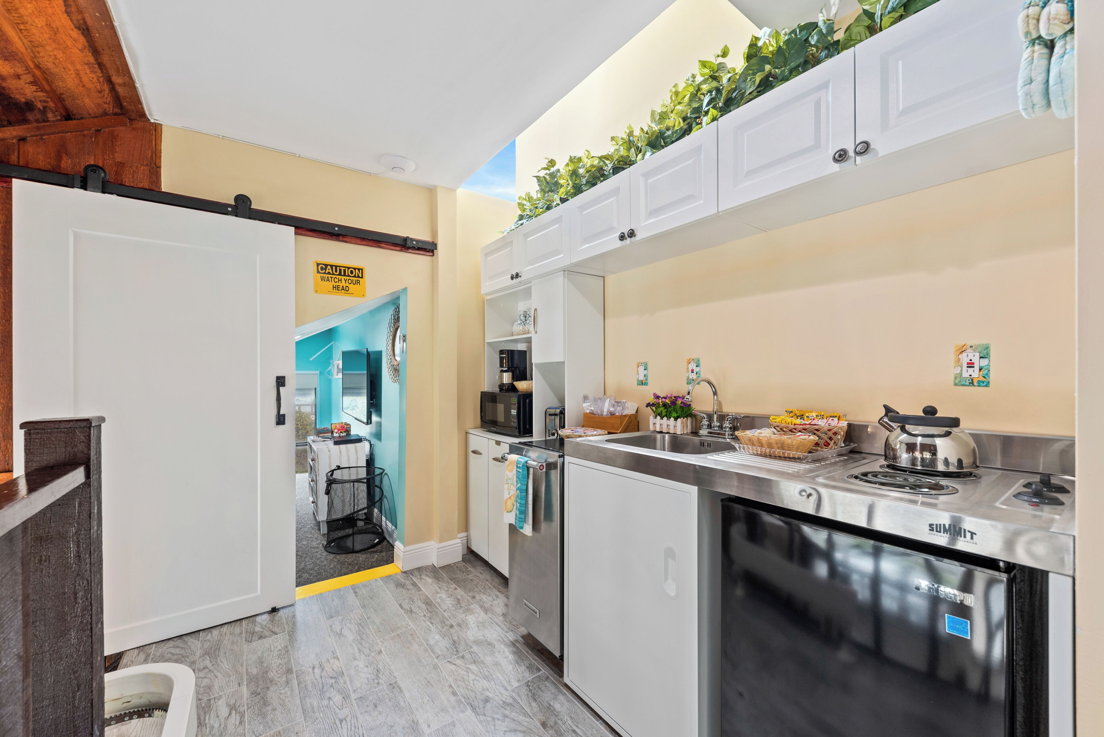 Een moderne keuken met roestvrijstalen apparatuur, een ingebouwde magnetron en een spoelbak.