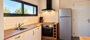 A compact kitchen with a Bosch oven, a built-in dishwasher, and a refrigerator.