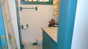 A small bathroom with a toilet, a sink, and a shower curtain. - Cobbler Suite, Private Entrance and Private bath, 100% NO SMOKING PROPERTY! (Hermann)