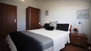 Ein Schlafzimmer mit einem Bett, einem Nachttisch, einer Lampe, einem Kleiderschrank und einer Wand mit einer Fahrradillustration.