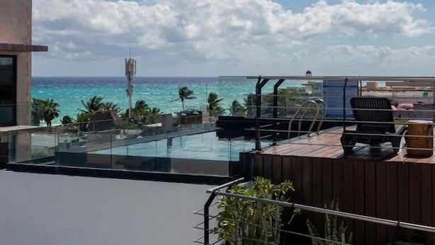 A rooftop terrace with a glass balustrade, a pool, and a view of the ocean. - Sole Suites Playa del Carmen (Playa del Carmen)