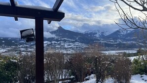 Un paisaje nevado con una cadena montañosa al fondo.