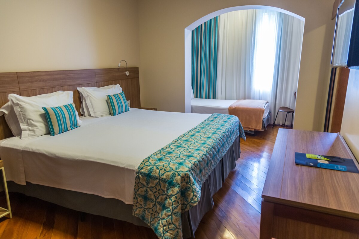Deluxe Triple Room | Minibar, in-room safe, desk, laptop workspace