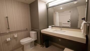 A modern bathroom with a toilet, sink, and shower area.