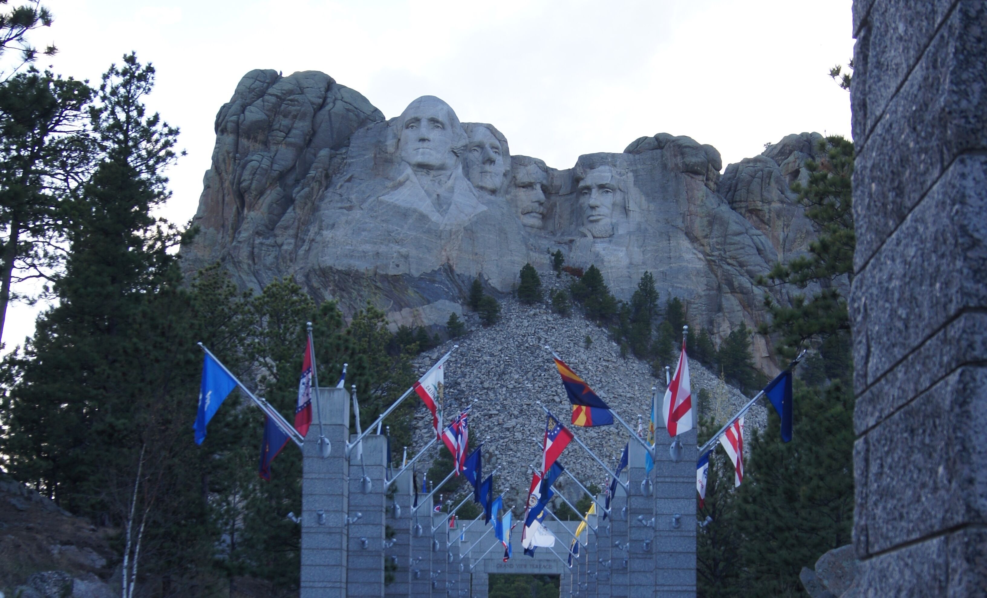 Un monument aux multiples facettes, avec des drapeaux devant.