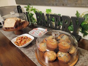 A bakery display with muffins, bread, and pastries.