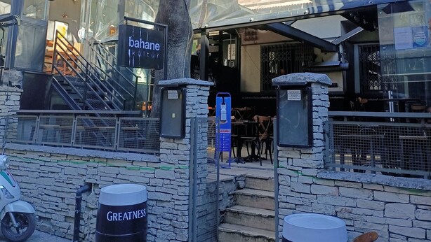 Un edificio con fachada de piedra, una escalera que lleva a la entrada y un área de estar al aire libre.
