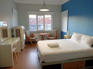 A bedroom with a bed, a desk, two chairs, a small table, and a window with a view of buildings. - Hostel Bahane (Istanbul)