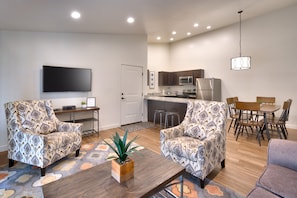 Relax in this cozy living space with a flat-screen TV, comfortable armchairs, and a dining area.