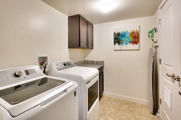A laundry room with a washing machine, dryer, and ironing board. - 5K Top Floor Moab Redcliff Condo, POOL & HOT TUB (Moab)