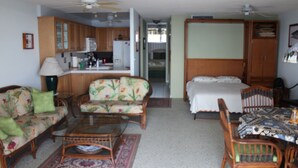 Un espace de vie compact comprenant une kitchenette, un coin repas et une chambre.