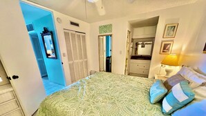 Un dormitorio con cama, mesita de noche, lámpara, cómoda y armario.