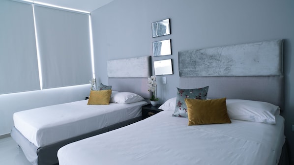 A hotel room with two beds, white bedding, and a large window providing natural light.