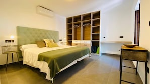 Ein Schlafzimmer mit Bett, Kleiderschrank, Nachttisch und Stuhl.