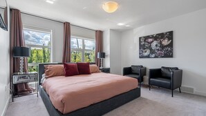 Une chambre moderne avec un grand lit, deux tables de chevet, un bureau, une chaise et une fenêtre avec des rideaux.
