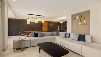 Una sala de estar moderna con un sofá seccional, una mesa de centro y un comedor con una mesa de madera y sillas.