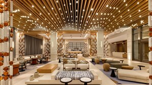 A spacious lobby with modern furniture, a central seating area, and a ceiling with numerous lights. - Hilton Cancun, an All-Inclusive Resort (Cancun)