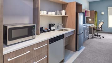 A modern kitchen with a microwave, coffee maker, and stainless steel refrigerator.