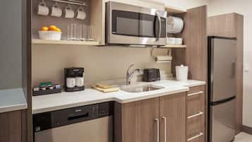 Una cocina moderna con microondas integrado, cafetera y lavavajillas.