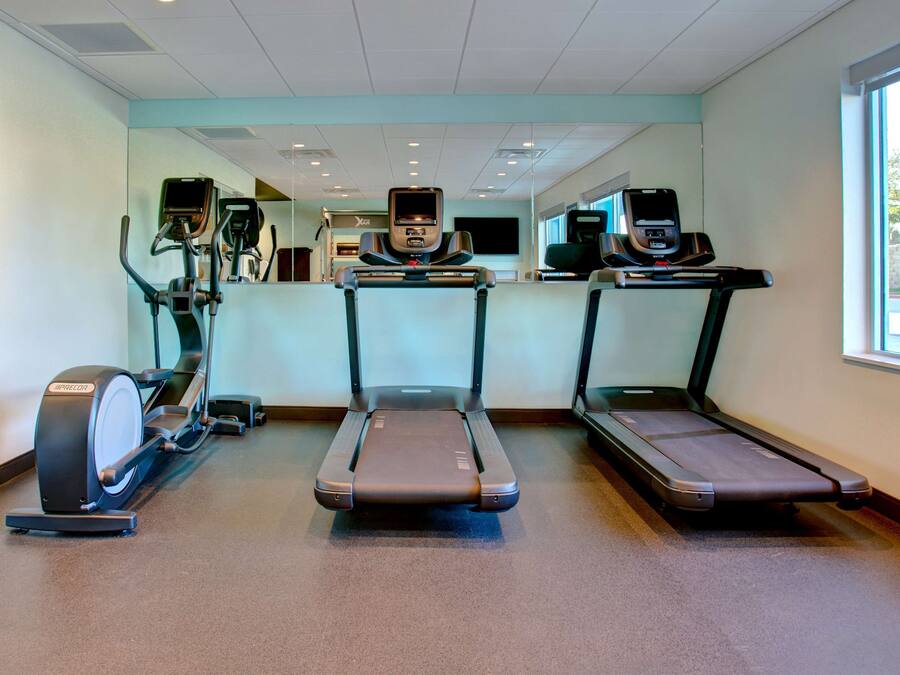 A fitness center with treadmills, elliptical machines, and stationary bikes.