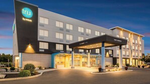 A modern hotel with a prominent 'tru by Hilton' sign, a covered entrance, and a well-lit facade. - Tru By Hilton Spokane Valley, WA (Spokane Valley)