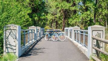 A paved pathway with a metal railing and bicycles parked on the side.