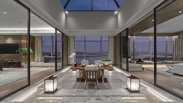 Un intérieur moderne comprenant un coin repas, de grandes fenêtres et une vue sur le paysage urbain.