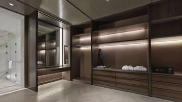 A modern bathroom with a large mirror, wooden vanity, and built-in shelves.