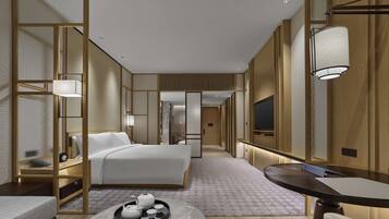 Une chambre d’hôtel moderne avec un grand lit, une table de chevet sur laquelle se trouve un plateau avec du thé, une petite table ronde et un téléviseur fixé au mur.