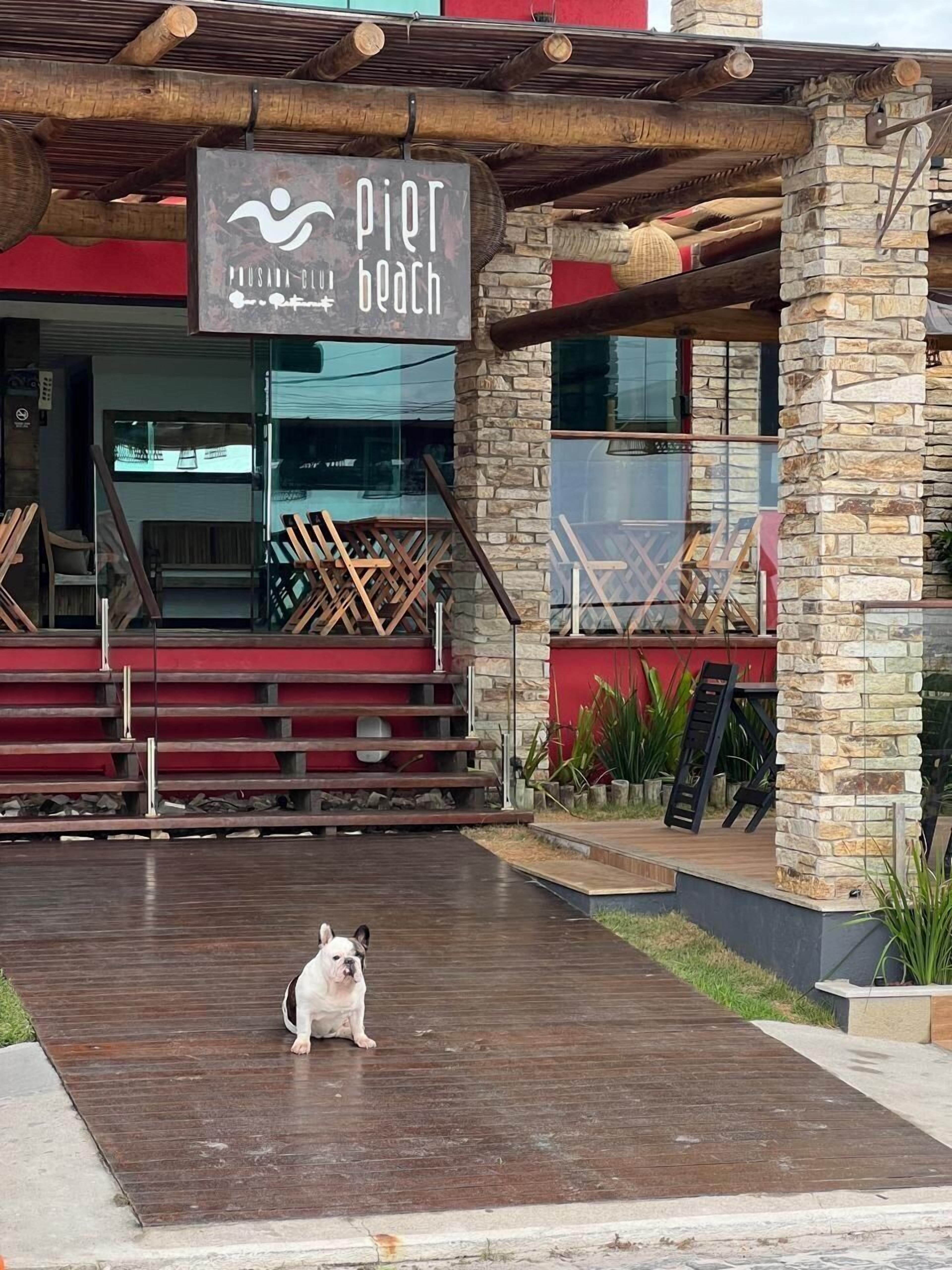 A building with a stone facade and a sign reading "Pier Beach".