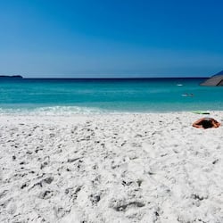 Sulla spiaggia, sabbia bianca, ombrelloni, teli da spiaggia