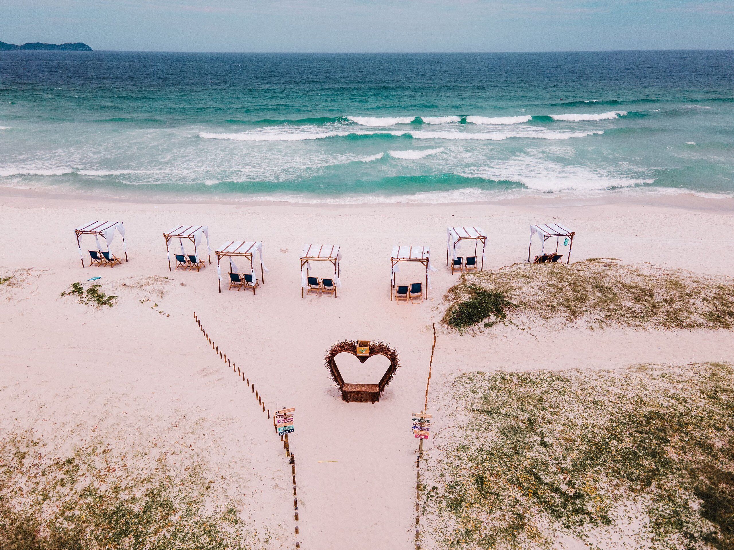 Rannalla, valkoista hiekkaa, aurinkovarjoja, rantapyyhkeitä