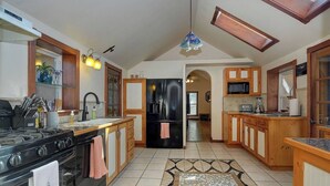 Una cocina con una isla central, armarios de madera, un refrigerador negro y una estufa.