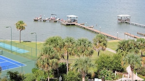 A lakeside view with a tennis court, palm trees, and docked boats. - 507 "A" Relaxing Bliss! Sept 13-20 Open! Book Soon! (Gulf Shroes)