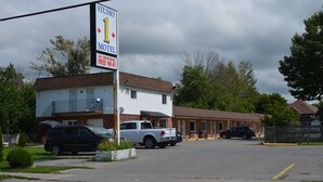 Een motel met een bord waarop staat dat het het eerste motel in de omgeving is, en gratis Wi-Fi en airconditioning biedt.