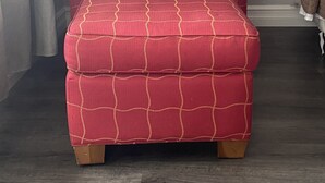 Een rode fauteuil met een ruitpatroon en een bijpassend pouf.