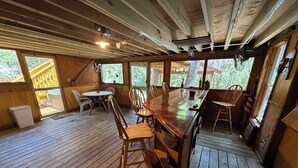 Un interno in legno con un tavolo da pranzo, sedie e una ventola.
