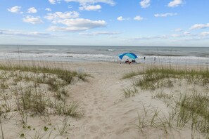 Ranta lähistöllä, aurinkotuoleja, rantapyyhkeitä