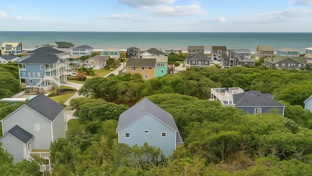 A coastal residential area with houses surrounded by greenery and a view of the ocean. - Captain’s Quarters - Private Beach Access! (Atlantic Beach)