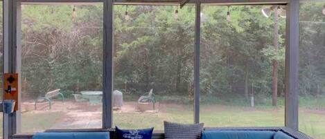 A covered outdoor seating area with a view of a lake and greenery.