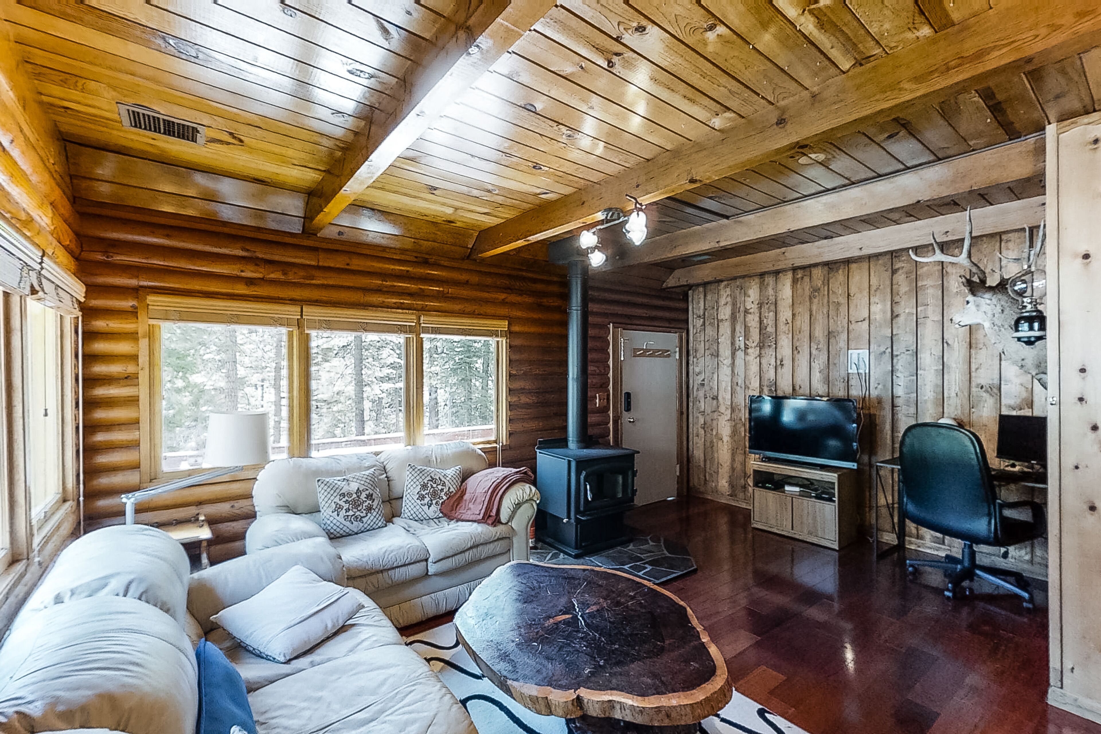 Rustic cabin-style home with wood stove, private gas grill, and picnic table