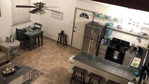 A compact kitchen with a dining area, a ceiling fan, and a small bar area. - PET FRIENDLY MAIN STREET LOFT, WALKING DISTANTANCE TO OLD TOWN TOMBALL (Tomball)