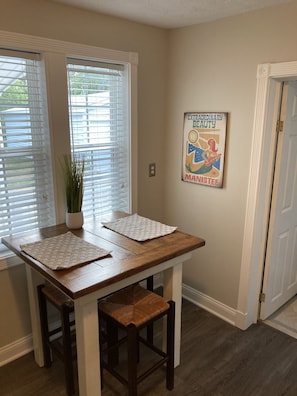 A dining area with a table, chairs, and a potted plant.