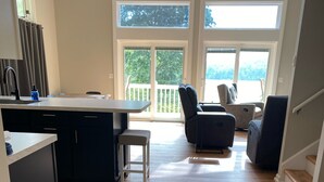 A spacious living area with a kitchen, a dining table, and a seating area with a view of the outdoors. - Lakefront Home in Private Cove of Deerfield Resort with Boat Slip. Pet-Friendly! (LaFollette)