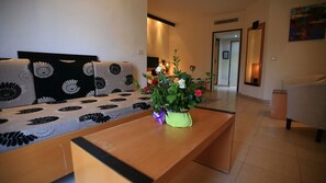 A living room with a sofa, a coffee table, and a flower vase. - Les Palmiers (Monastir)